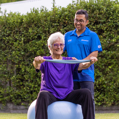 A BlueCare employee helps an older lady