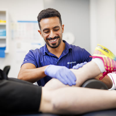 A BlueCare employee assists an older person with exercise