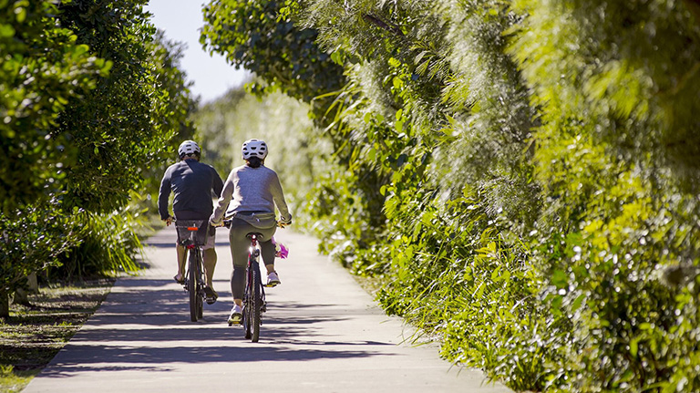 Couple riding bikes in the surrounding area of Bokarina Beach Village