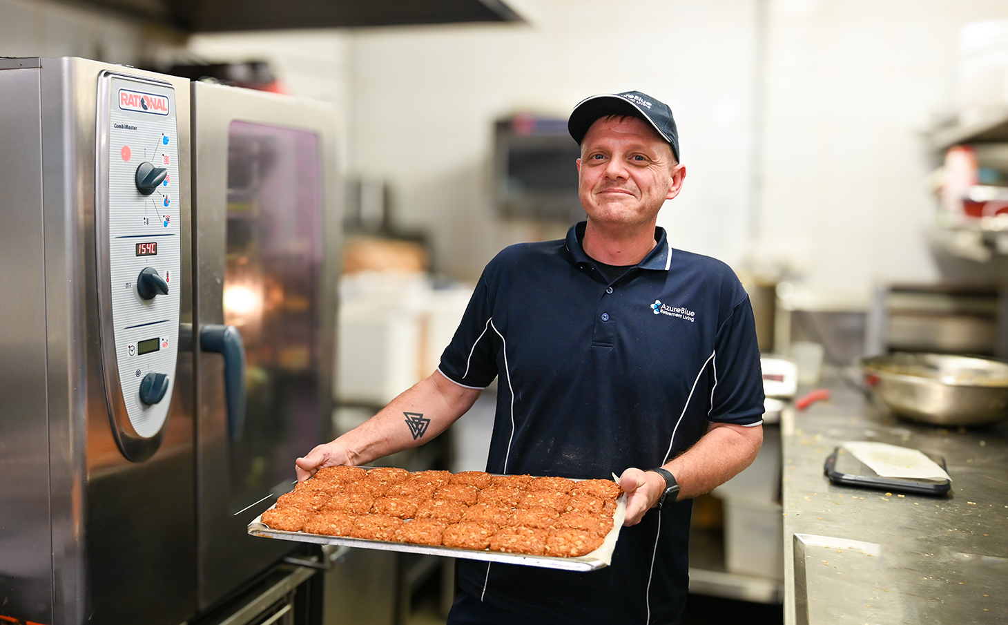 Andrew Chef at Azure Blue Redcliffe hold a tray of anzac biscuits in the kitchen.