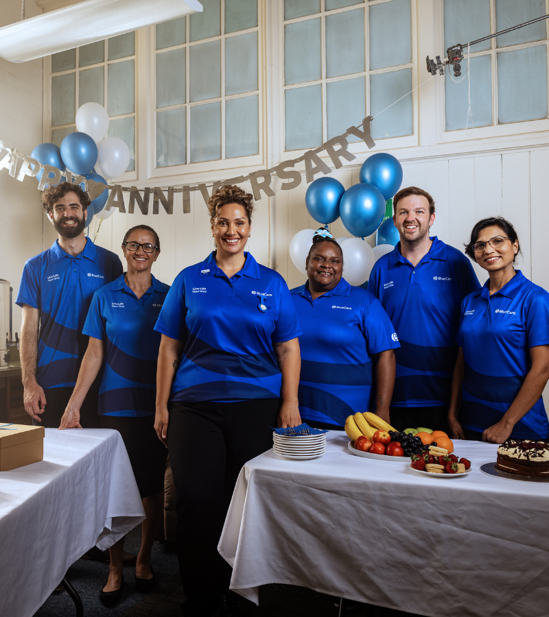 Team of BlueCare team standing around table