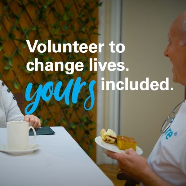 A man and a woman smiling at each other as they have a cup of tea