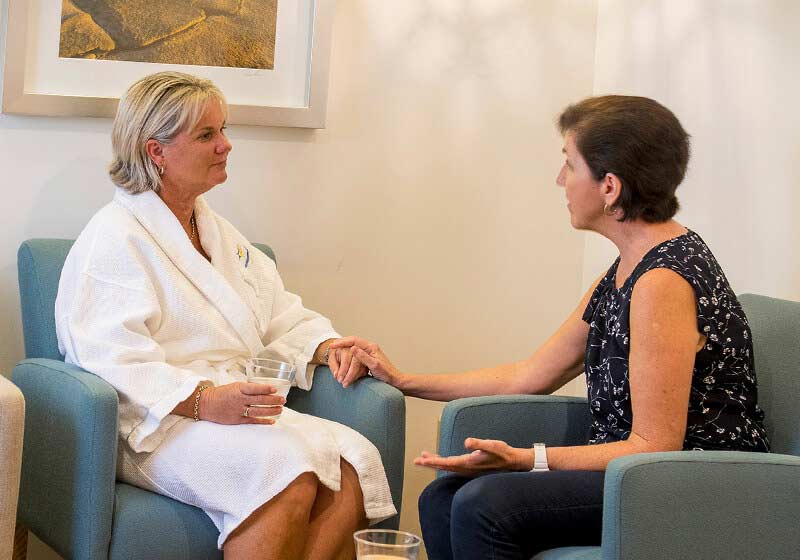 Client and staff member discussing treatment in waiting room