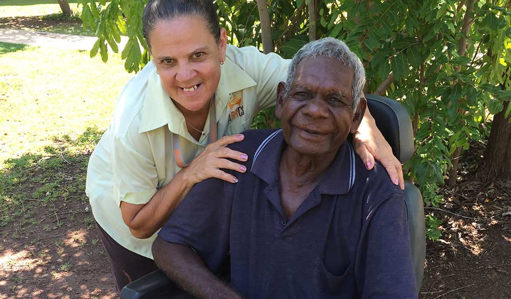 staff member posing with elderly indigenous client outdoors