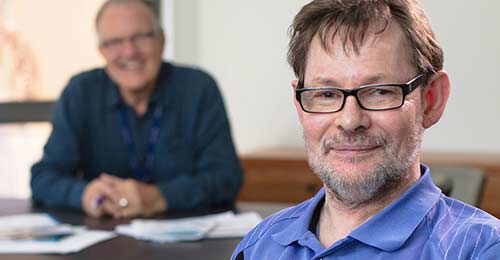 man sitting at a desk smiling