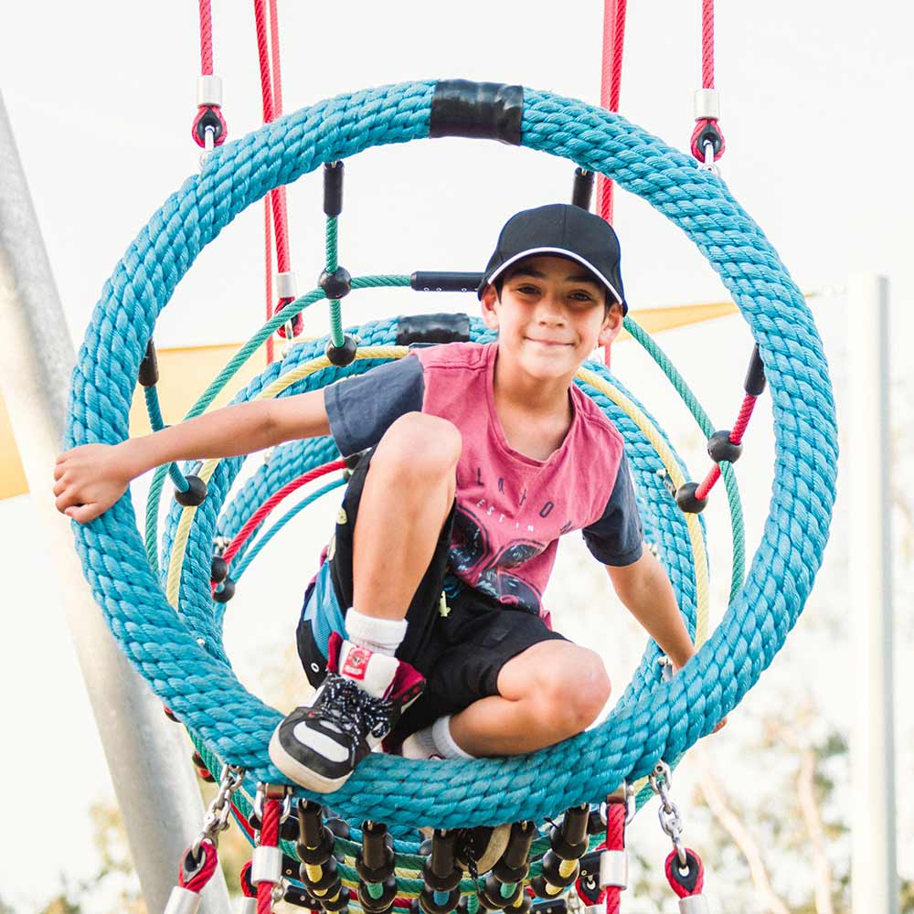 Young boy smiling at camera in playground