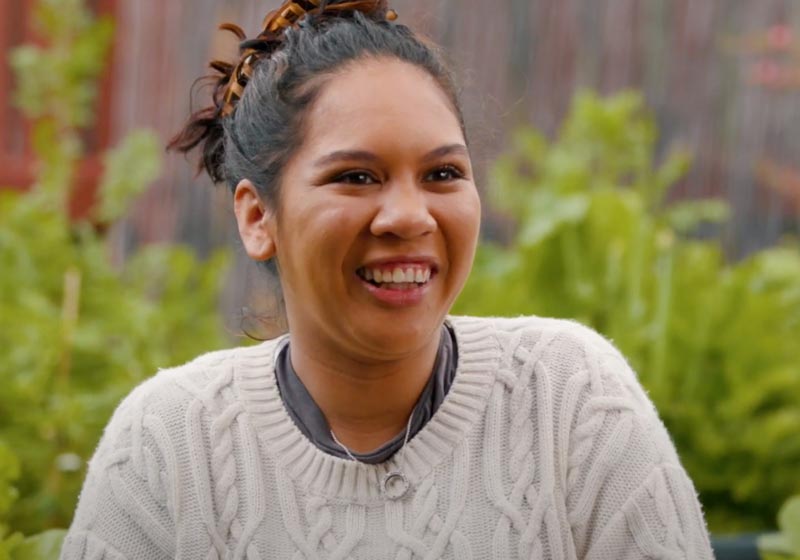 Lady sitting in garden talking and smiling to camera
