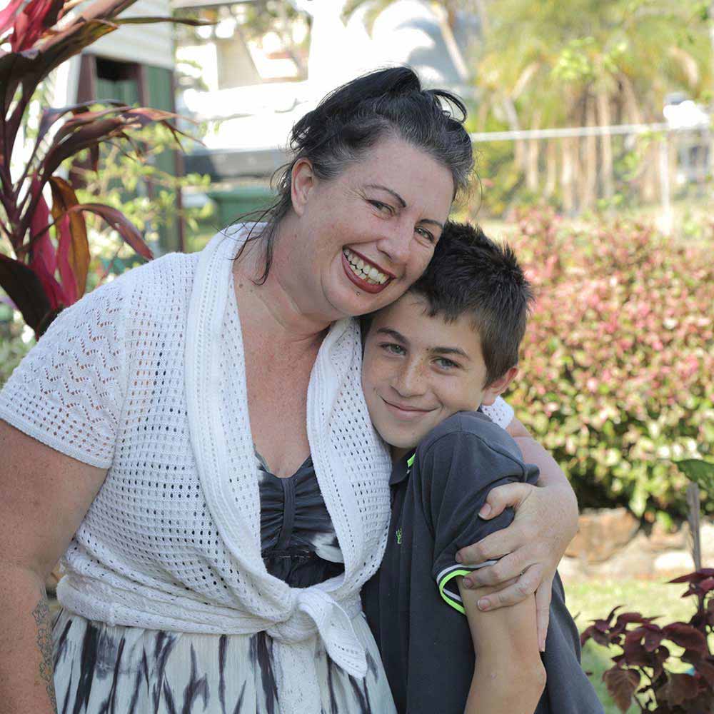 mother and son hugging and smiling outside