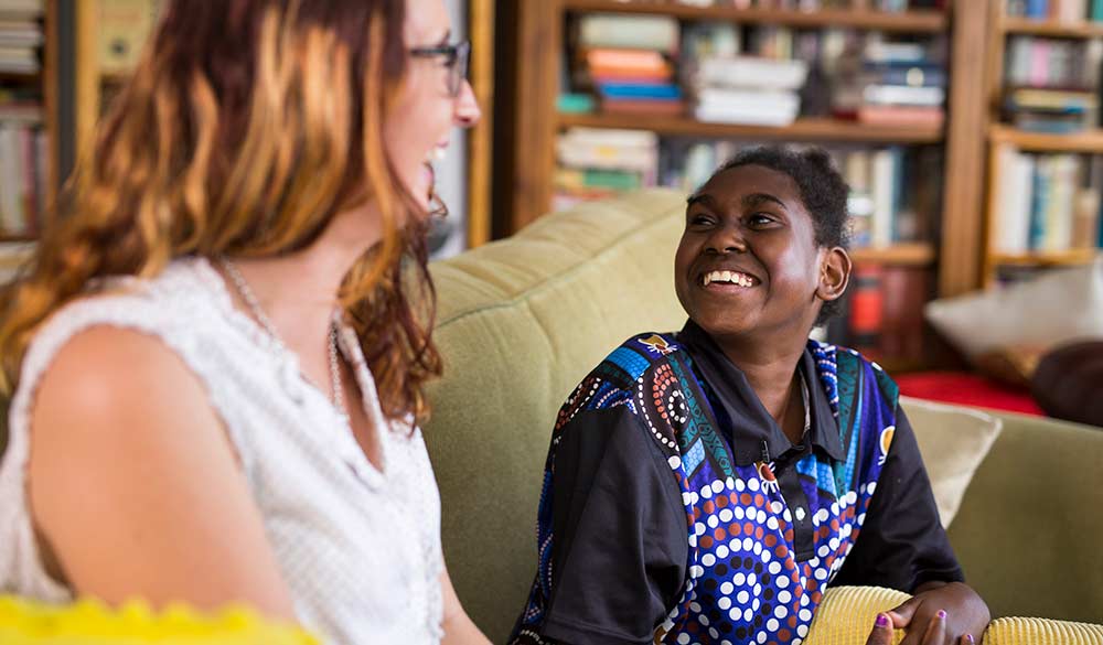 young indigenous woman laughing with female staff member