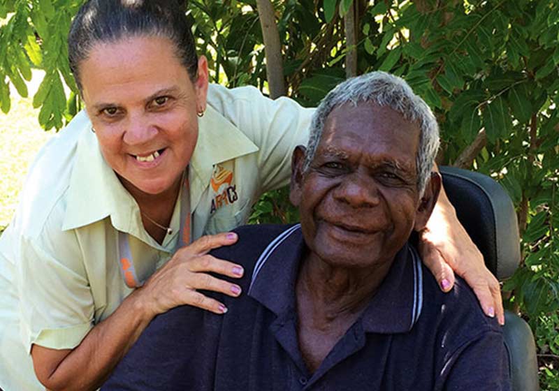 staff member posing with elderly indigenous client outdoors