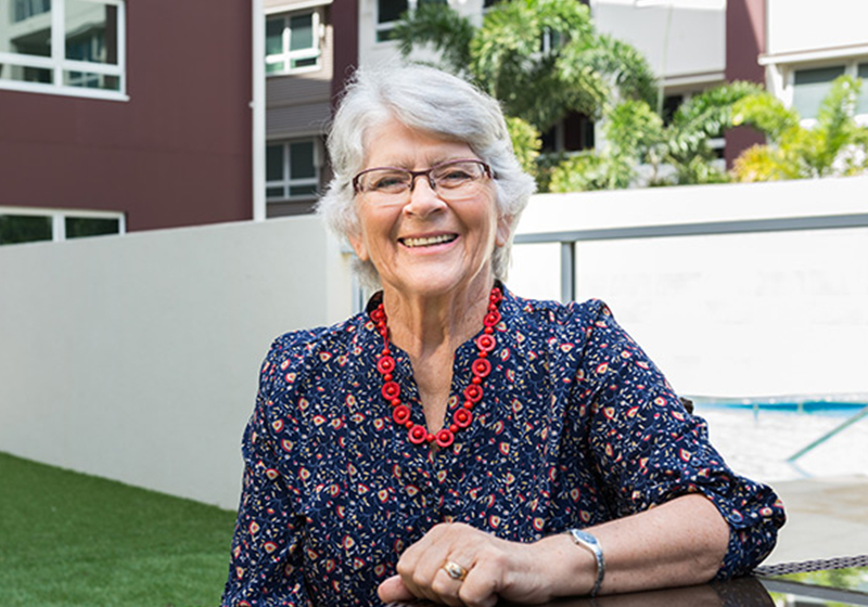 elderly lady sitting outside smiling