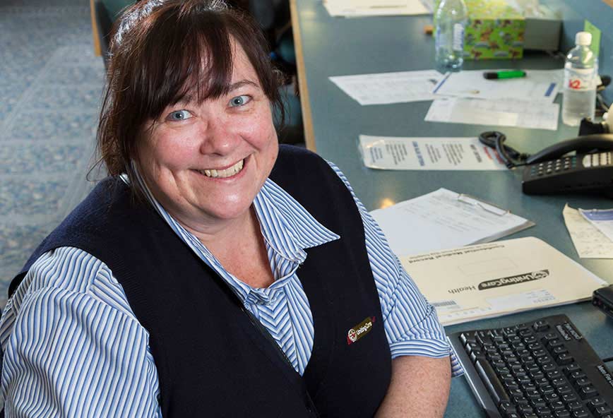 happy staff member at her desk smiling