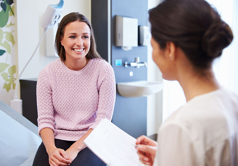 happy female patient talking to woman doctor