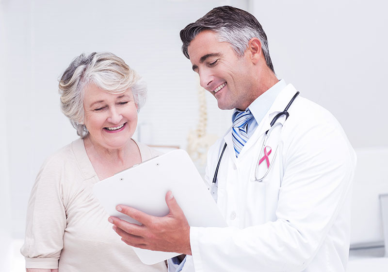 cancer doctor giving good news to grey haired woman patient