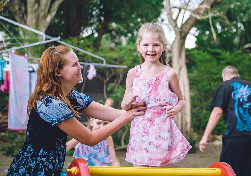 mum playing with her daughter in a pink dress