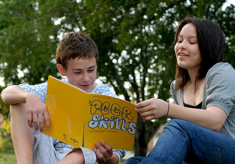 children reading book outside