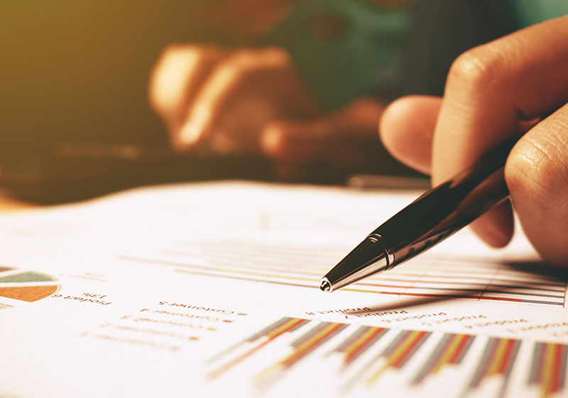 pen pointing to graphs on a page