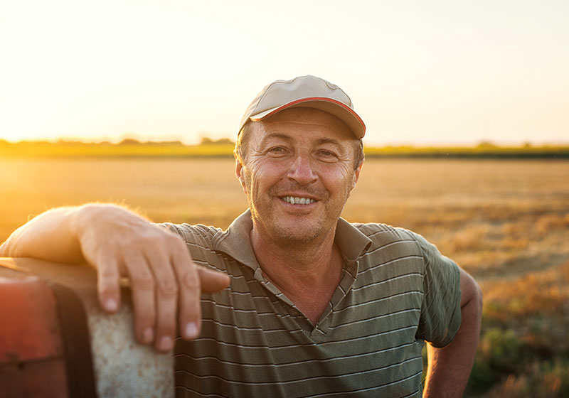 happy farmer in field at sunset
