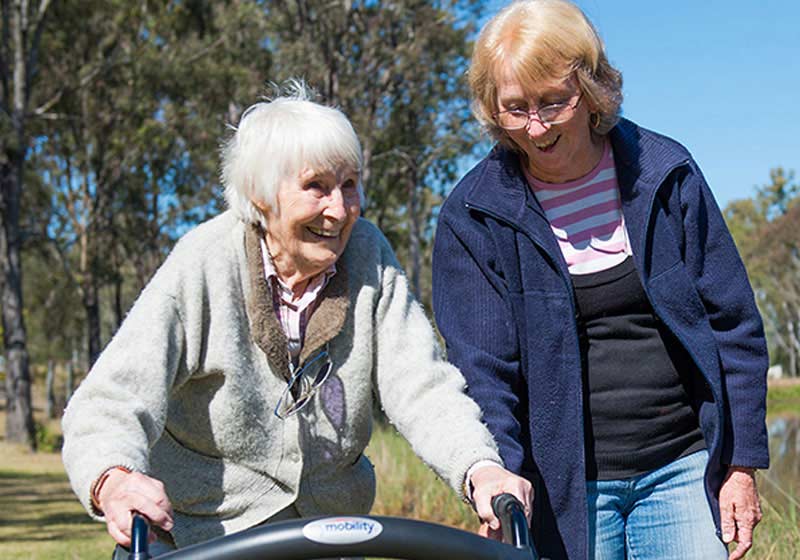 woman volunteering with the elderly in park