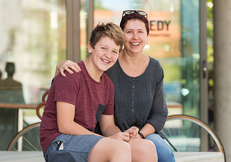 young boy with mum embracing on stoop