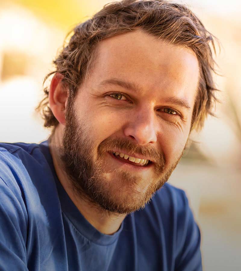 young man wearing a blue shirt smiling