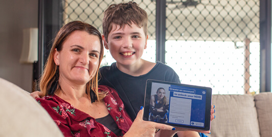 Mother and son holding tablet with NDIS planning App