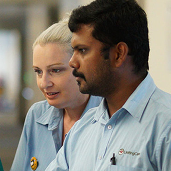 Two participants of the graduate nurse program gather around a monitor at St Stephen’s Hospital.
