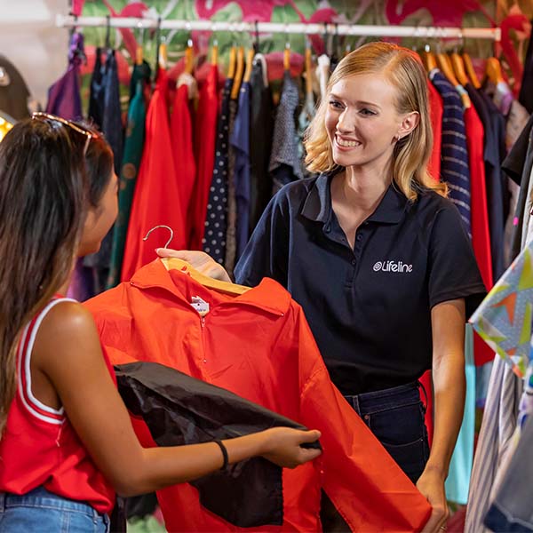 A team member showing a customer some clothes