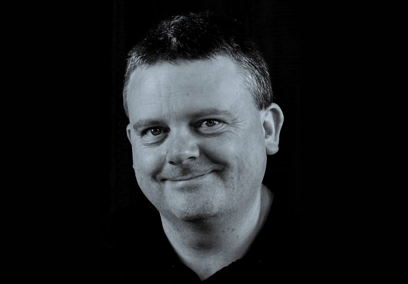 A monochrome image of DJ Cronin smiling 