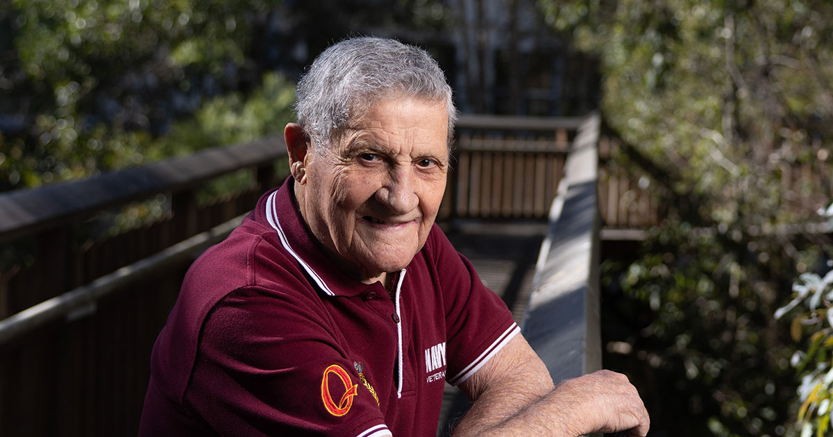 Navy Veteran and Azure Blue Carina Resident Rudi Bianchi standing on footbridge with trees and bush in background smiling at camera