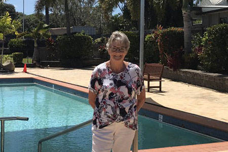 Carlyle Gardens resident standing in front of pool
