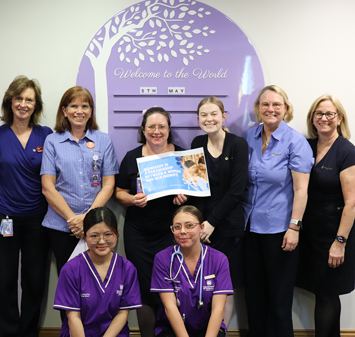Wesley Midwives standing in front of wall art