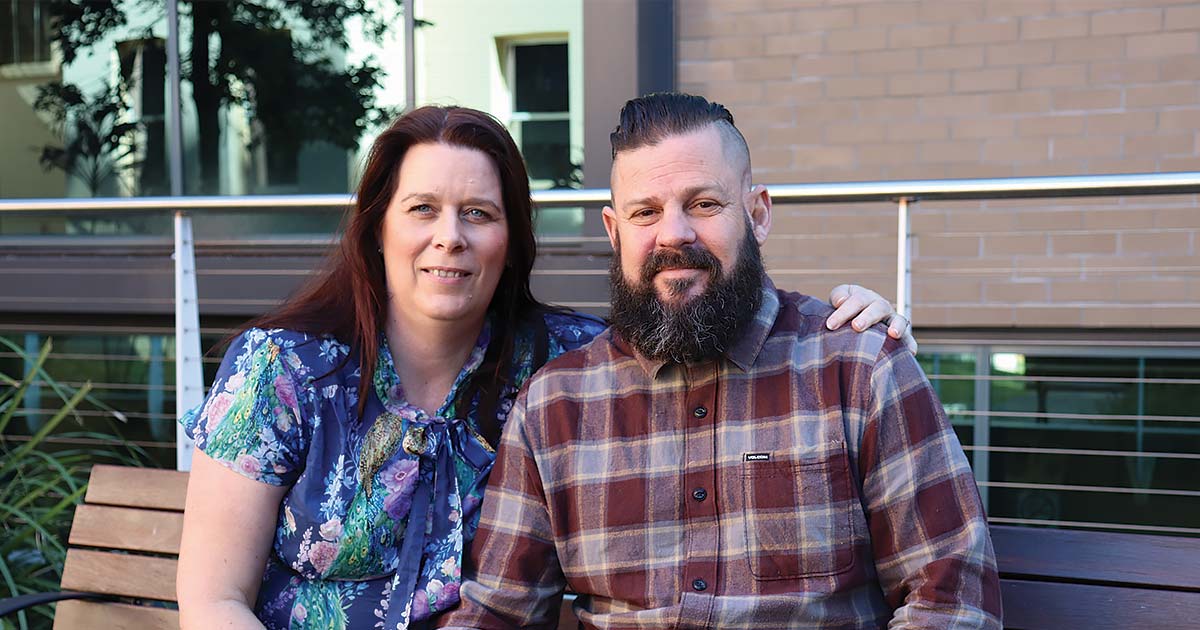 Simon with his wife seated outside The Wesley Hospital