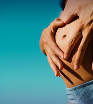 Hands holding a pregnant belly.